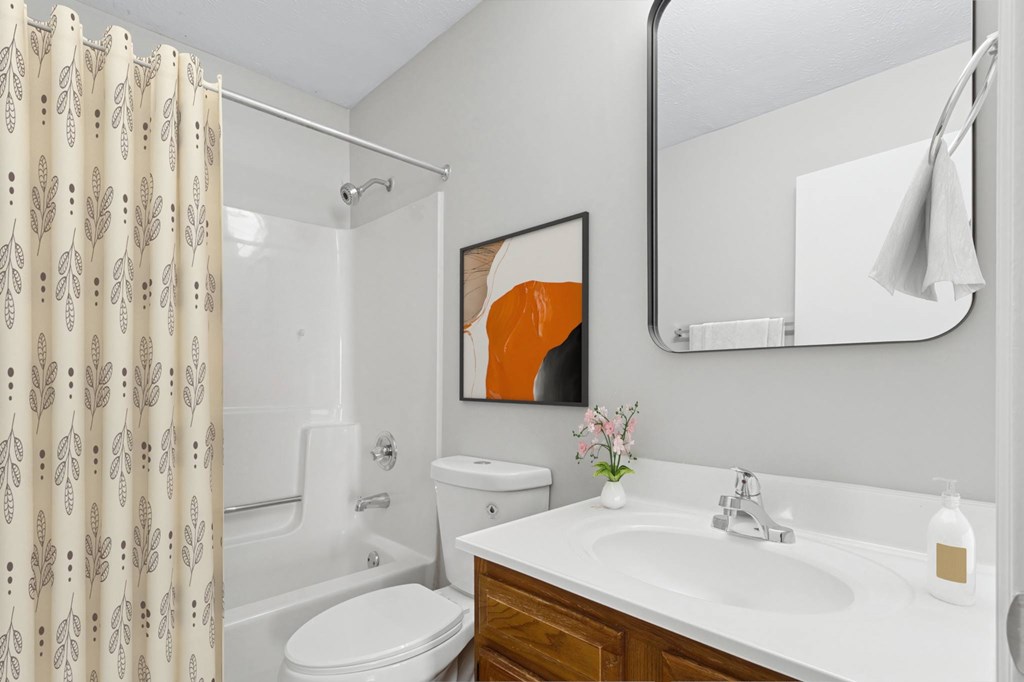 A bathroom with a toilet, sink, and shower.