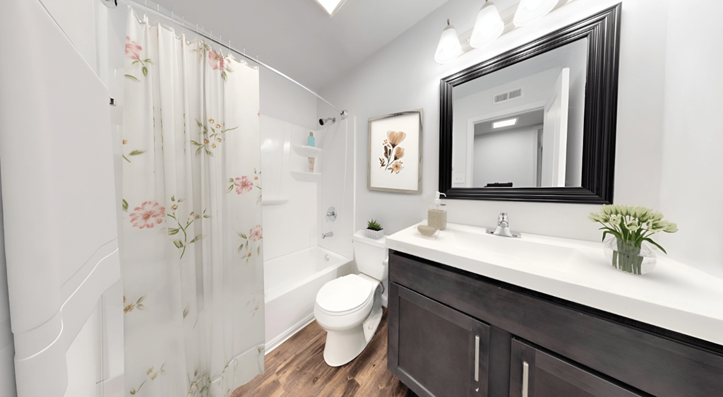 a bathroom with a toilet sink and shower and a mirror