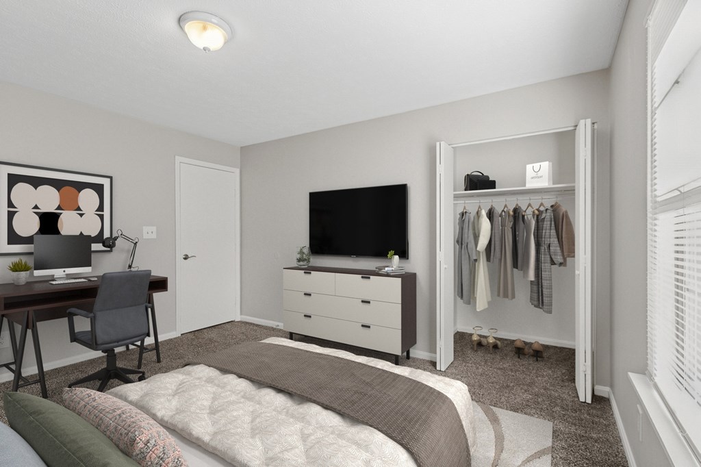 A bedroom with a bed, desk, and closet.