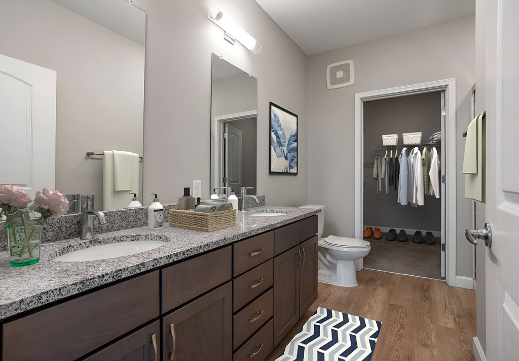 a bathroom with two sinks and a toilet and a mirror at Adelphi Quarter, Columbus