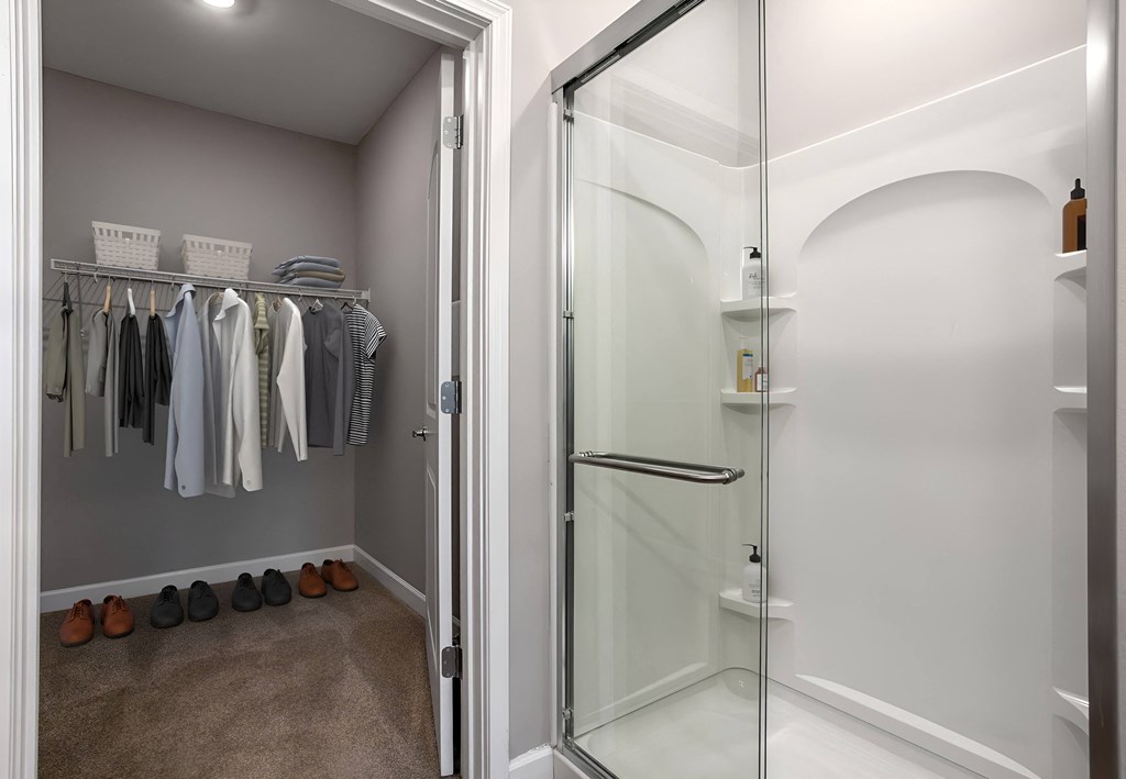 a walk in closet with a glass shower and some clothes on a rack at Adelphi Quarter, Columbus, OH