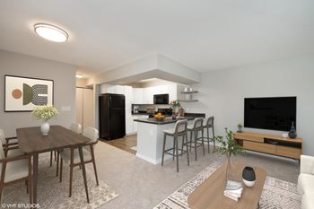 A modern living room with a dining table and chairs.