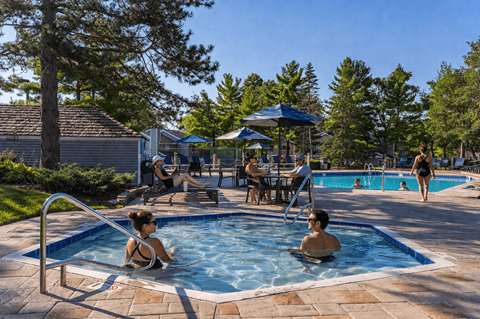 People are enjoying a sunny day at the poolside.