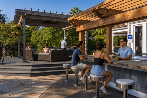 People are sitting at a bar under a wooden pergola.