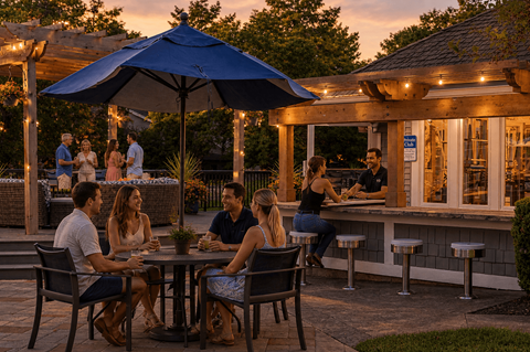 A group of people are sitting at a table under a blue umbrella.