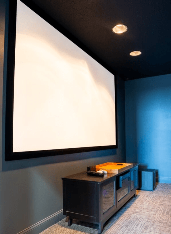 Projector screen in a blue room with a wooden table