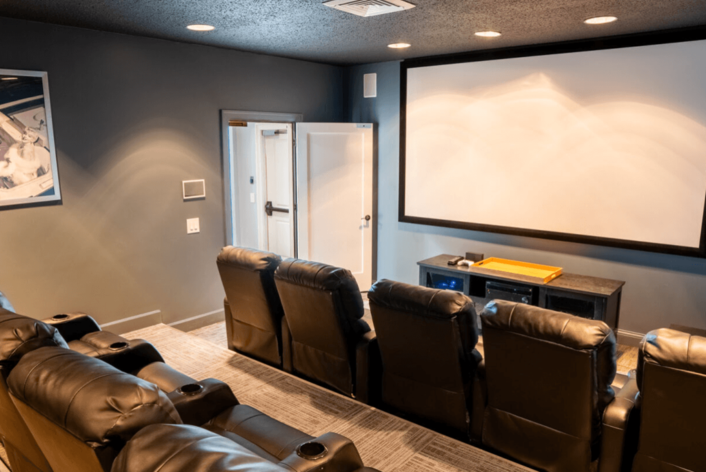 Screening room with leather chairs and a projector screen