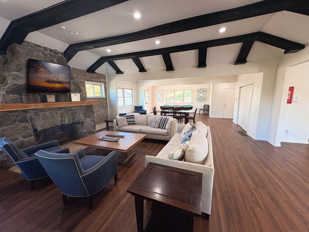 A living room with a stone fireplace and a large couch.