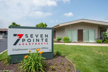 A sign for Seven Pointe Apartments in front of a building.