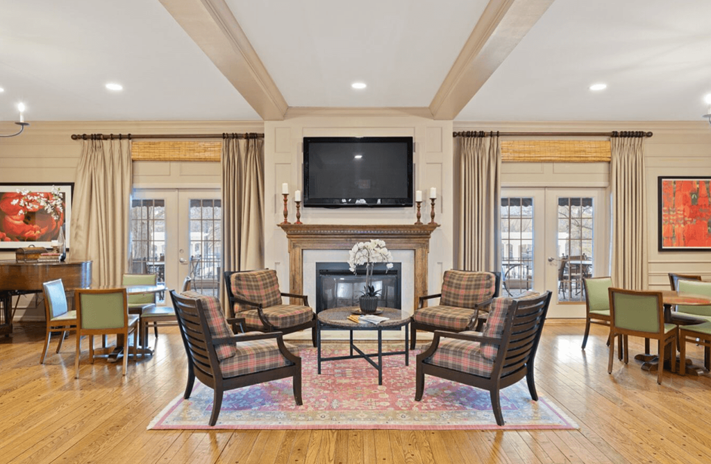 Living room with a fireplace and a table and chairs at Indian Creek Apartments, Cincinnati, OH, 45236