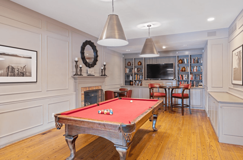 a game room with two pool tables and a television