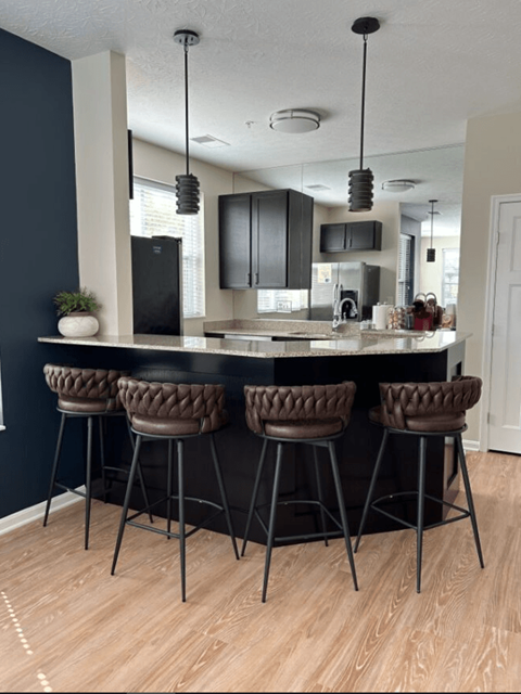 a kitchen with a counter top and some chairs
