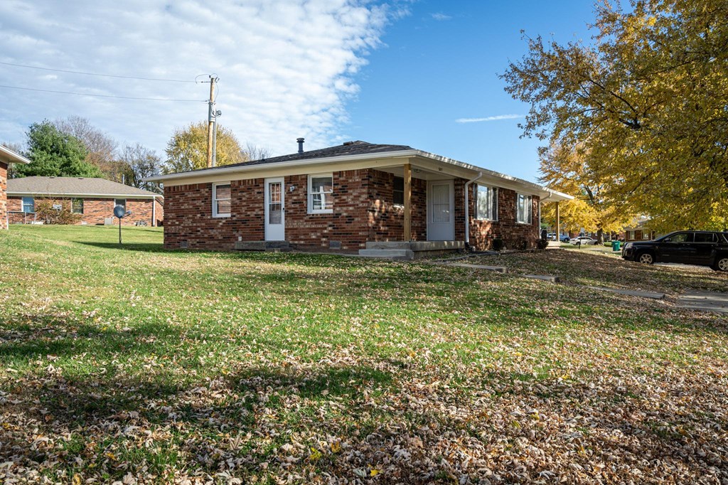 a small brick house with a lawn in front of it at Stonebrook of Franklin, Franklin