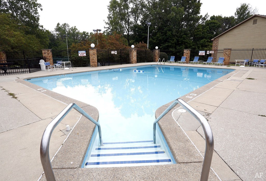 A pool with a metal staircase leading down to it.
