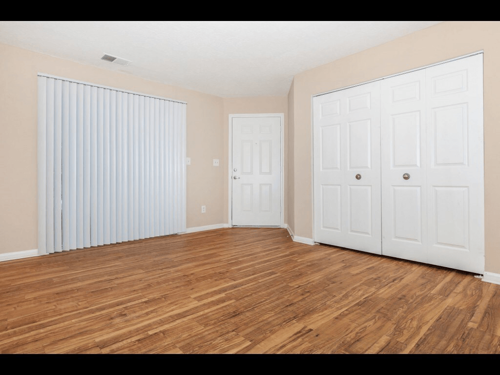 A room with wooden floors and two white doors.