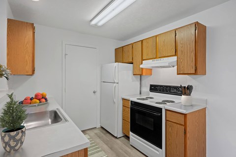 A kitchen with wooden cabinets and a white fridge.