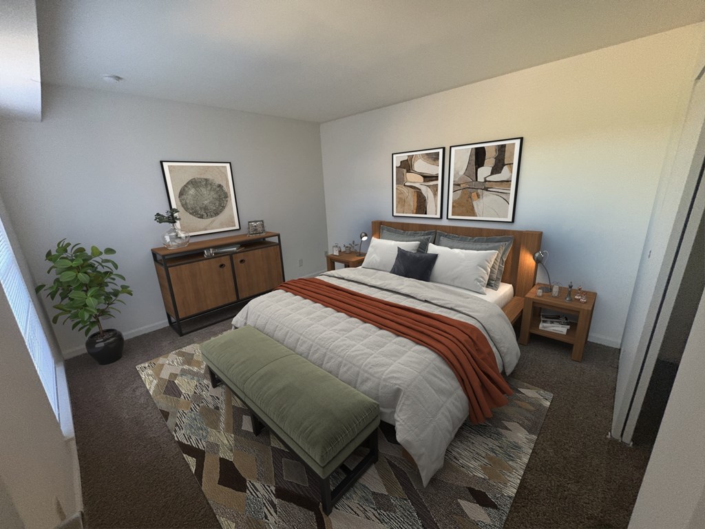 A bedroom with a bed, a bench, and a plant.