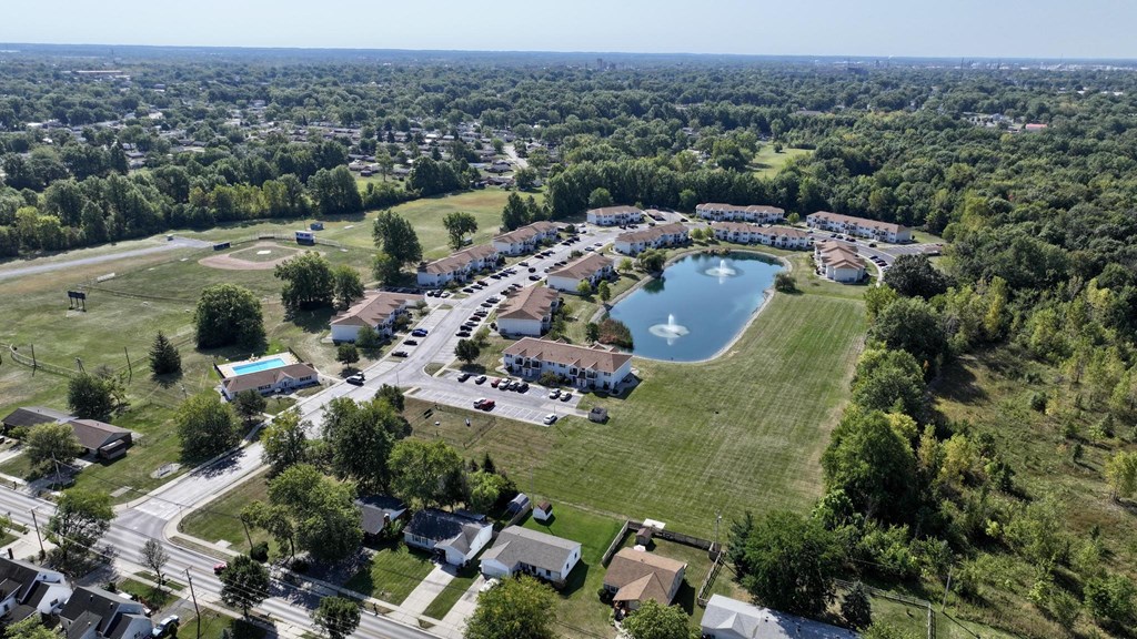 A bird's eye view of a residential area with a swimming pool and a large building.