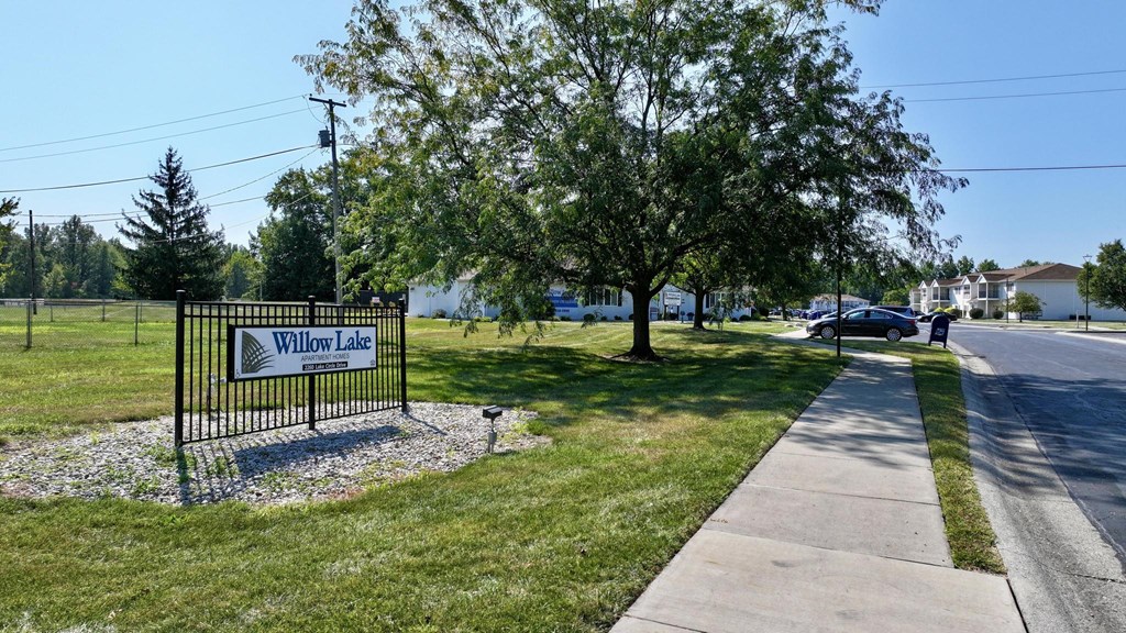 A sign that says Willow Lake stands in front of a grassy area.