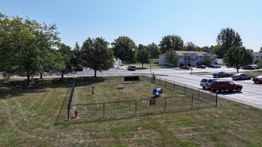 A park with a basketball court and a red fire hydrant.