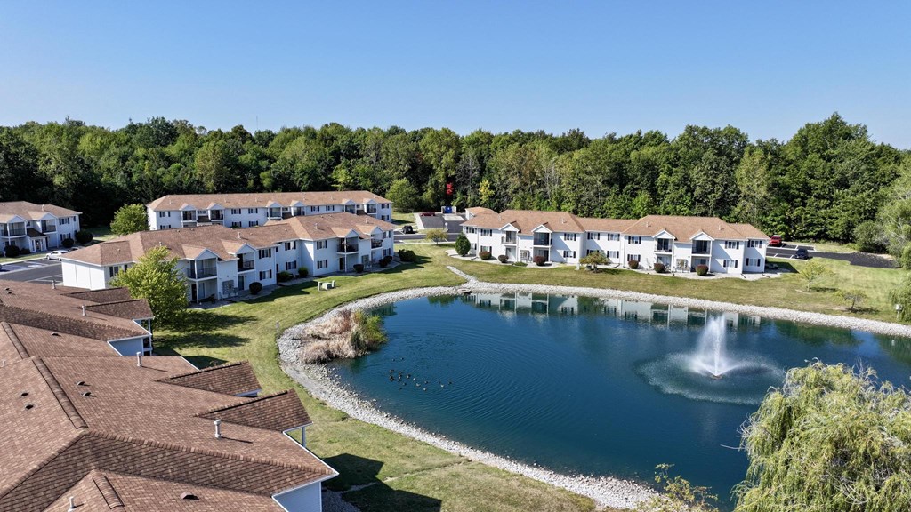 A large white building with a pool in front of it.
