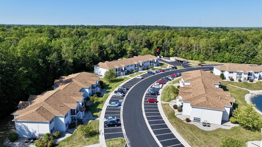 A road with cars and houses on both sides.