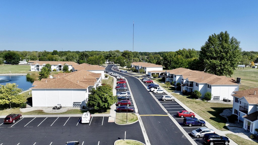A parking lot with cars parked in rows in front of a building.
