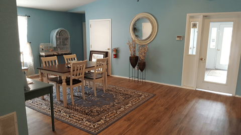 A dining room with a table and chairs.