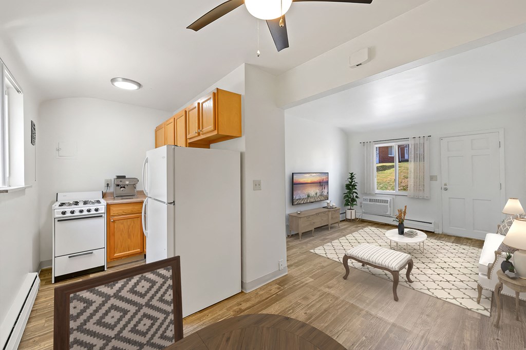 a kitchen and living room with white appliances and wood floors