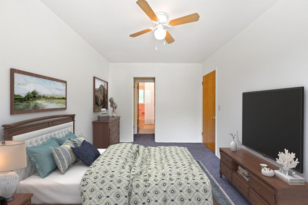 a bedroom with a large bed and a ceiling fan