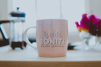 a pink coffee mug with the words its wild bonita on it
