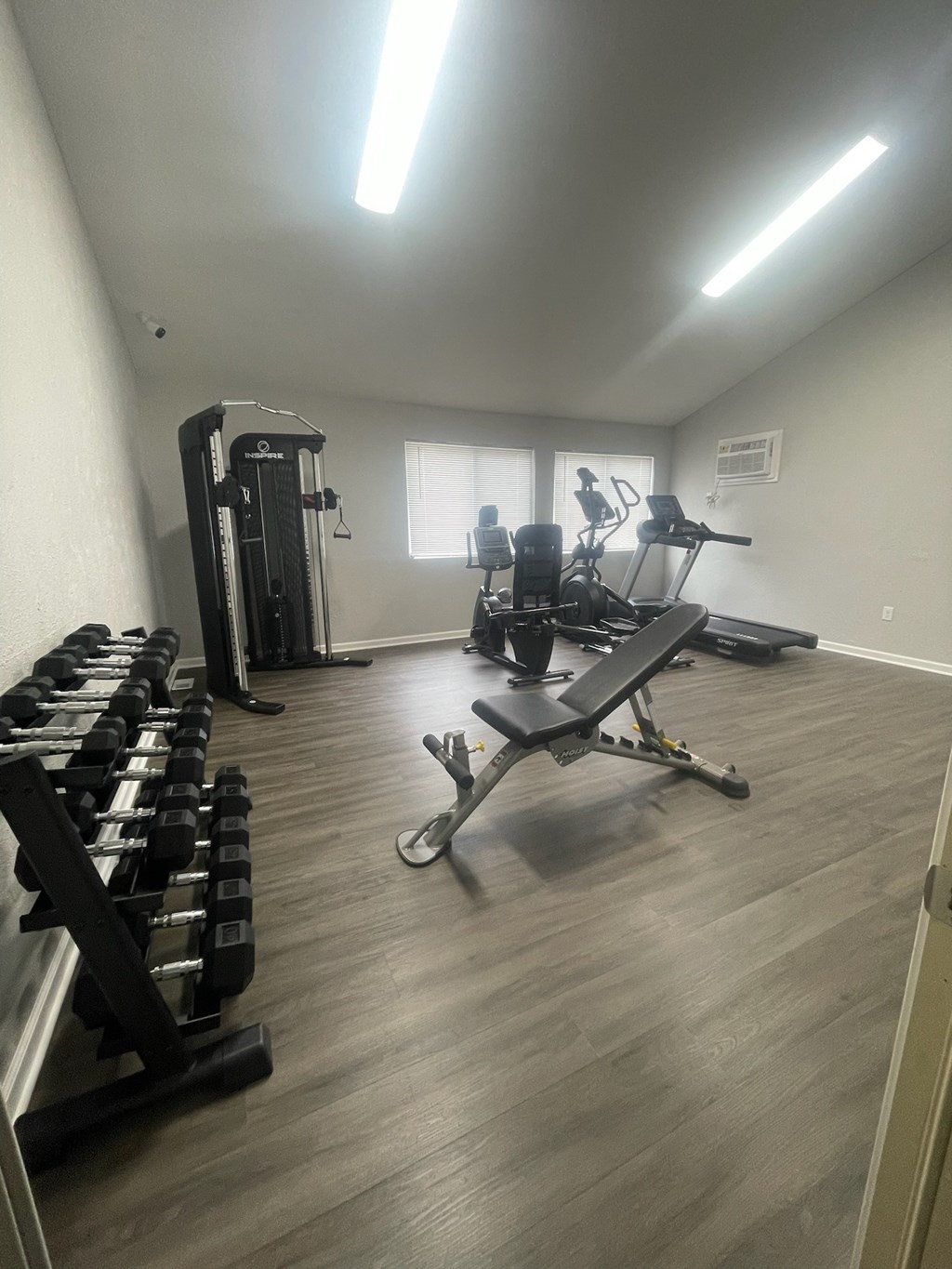 A gym with a variety of equipment including weights and a bench press.