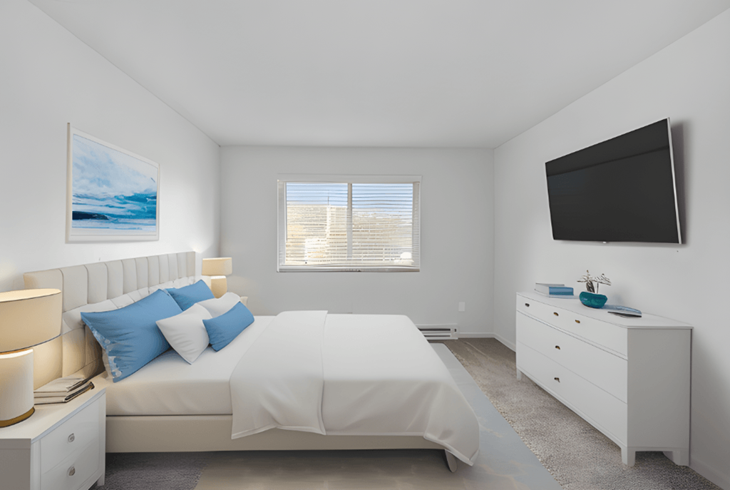 a white bedroom with a white bed and a television