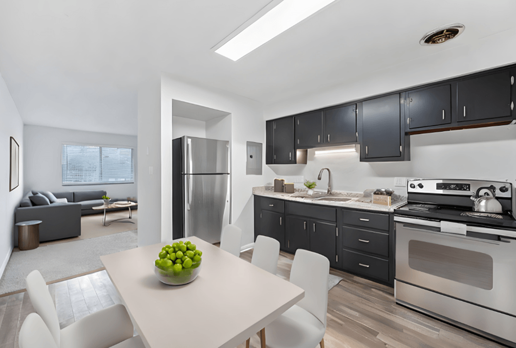 a kitchen and dining room with black cabinets and stainless steel appliances