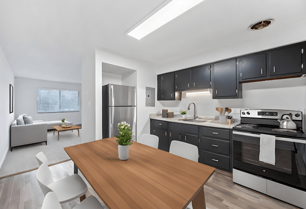 a kitchen and dining room with black cabinets and a wooden table