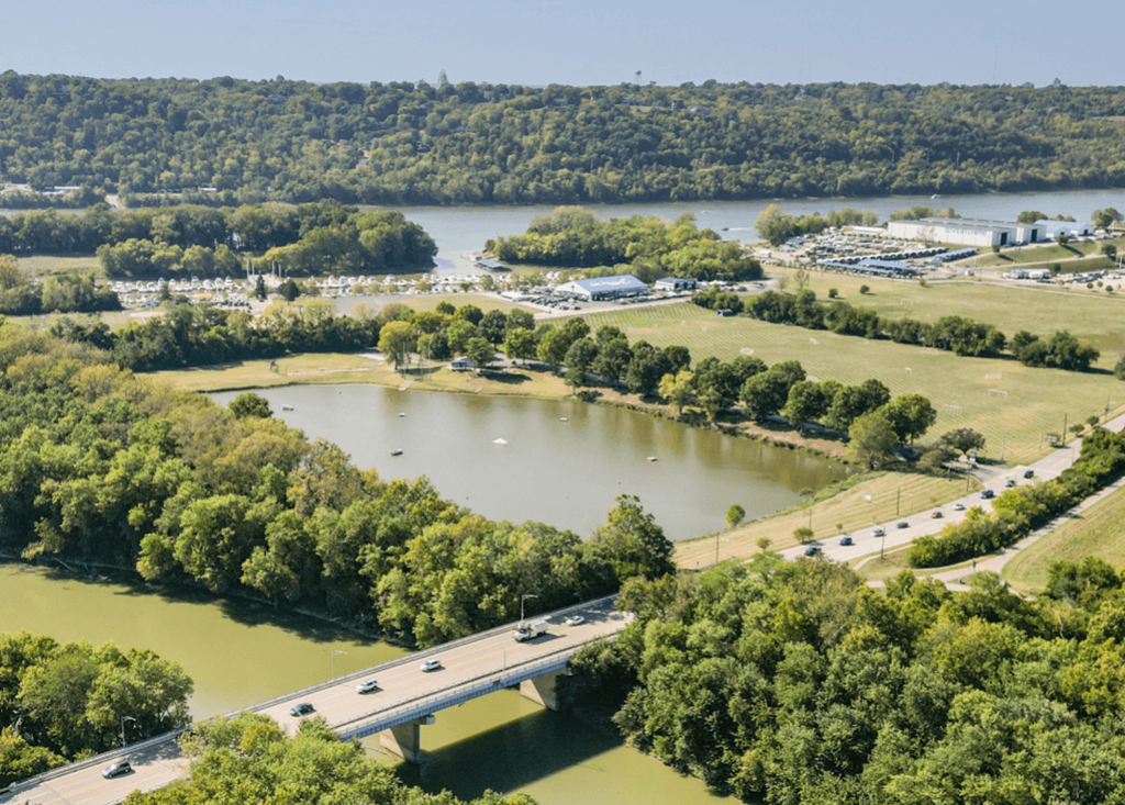 an aerial view of a lake next to a highway and a bridge