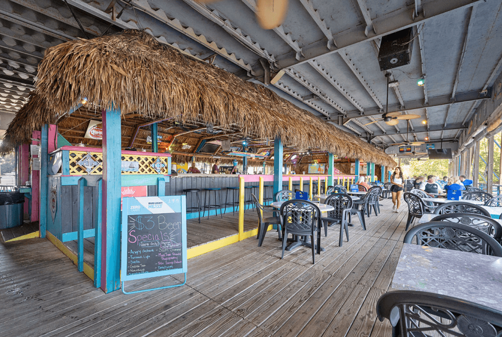 a view of the outside of a restaurant with tables and chairs