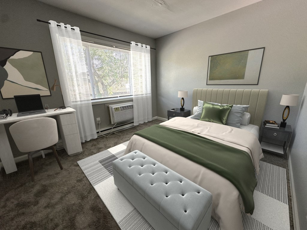 a bedroom with a bed and a desk with a laptop