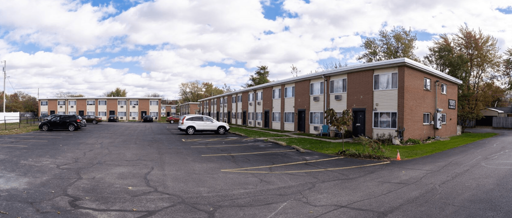 an empty parking lot in front of an apartment building