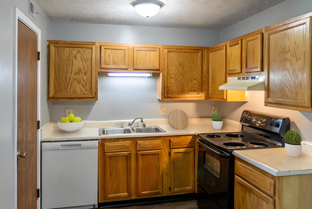 Kitchen with white appliances and wooden cabinets at Crossings of Kenton, Erlanger, KY, 41018