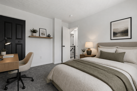 A bedroom with a large bed and a chair.