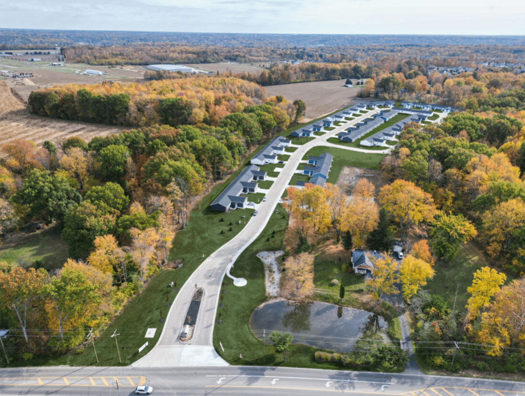 an aerial view of a parking lot with trees and a highway