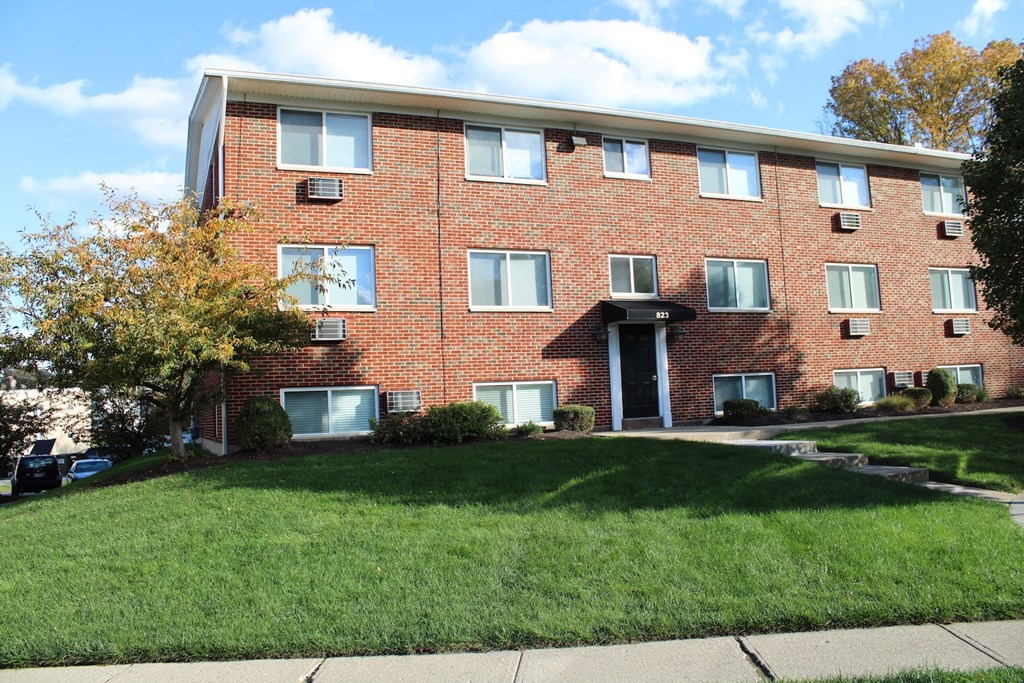 A red brick building with a white door and windows.