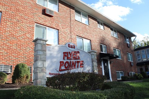 A brick building with a sign that says Flyer Pointe.