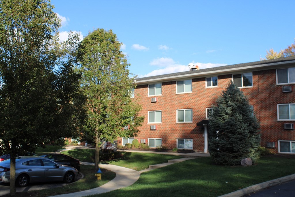 A red brick building with a tree in front of it.