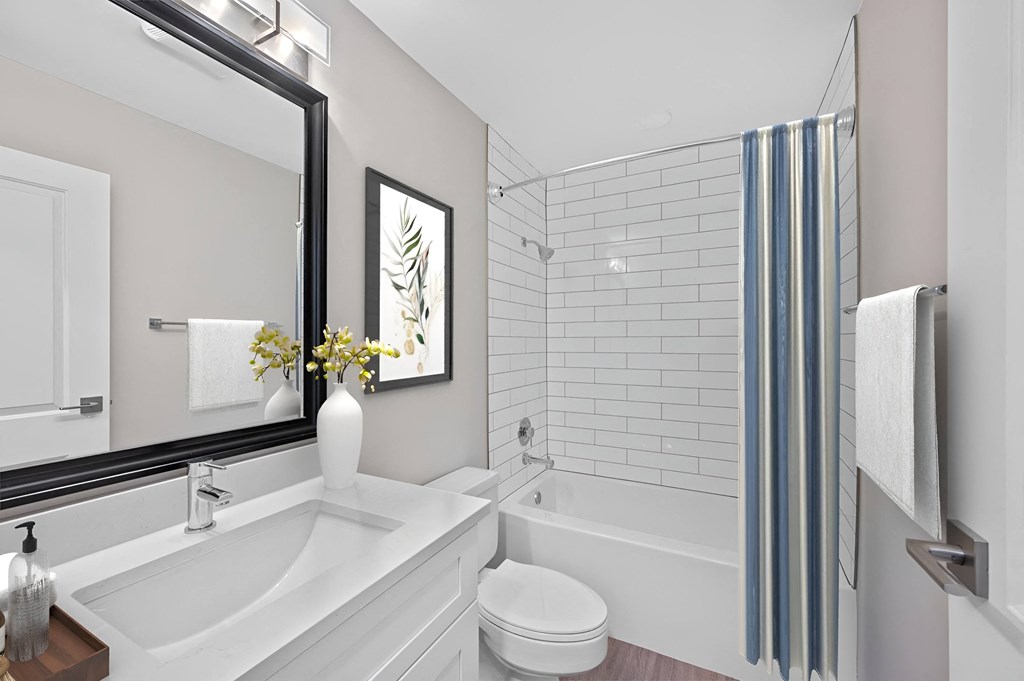 a white bathroom with a large mirror and a tub and a sink at Indian Creek Apartments*, Cincinnati, OH