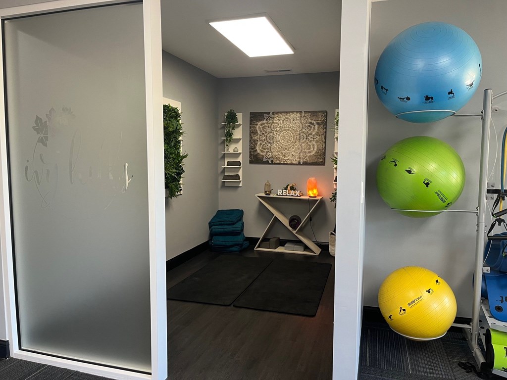 A room with a yoga ball, a foam roller, and a massage table.
