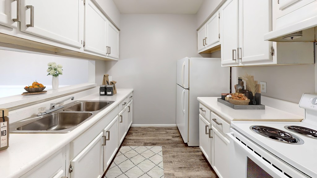 A kitchen with white cabinets and appliances.