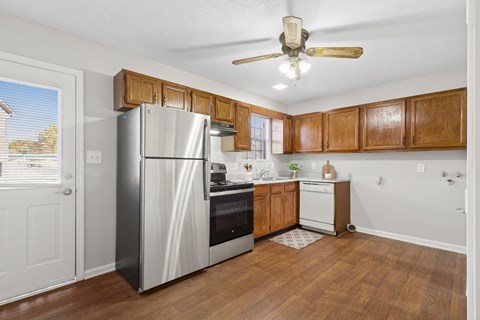 A kitchen with wooden cabinets and a stainless steel refrigerator.