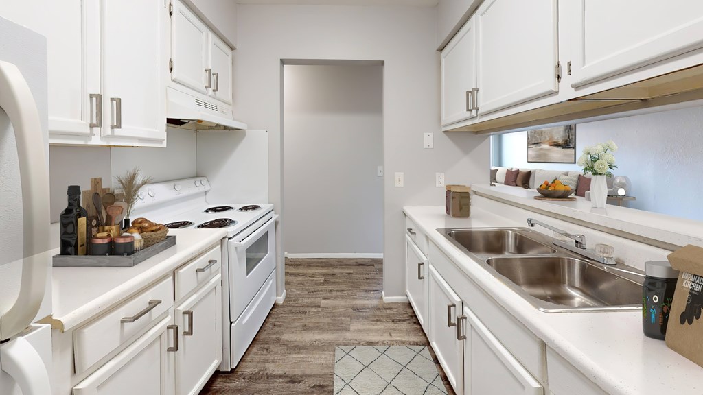 A kitchen with white cabinets and appliances.